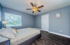 Cozy retreat with a single bed, ceiling fan, and window with blinds.