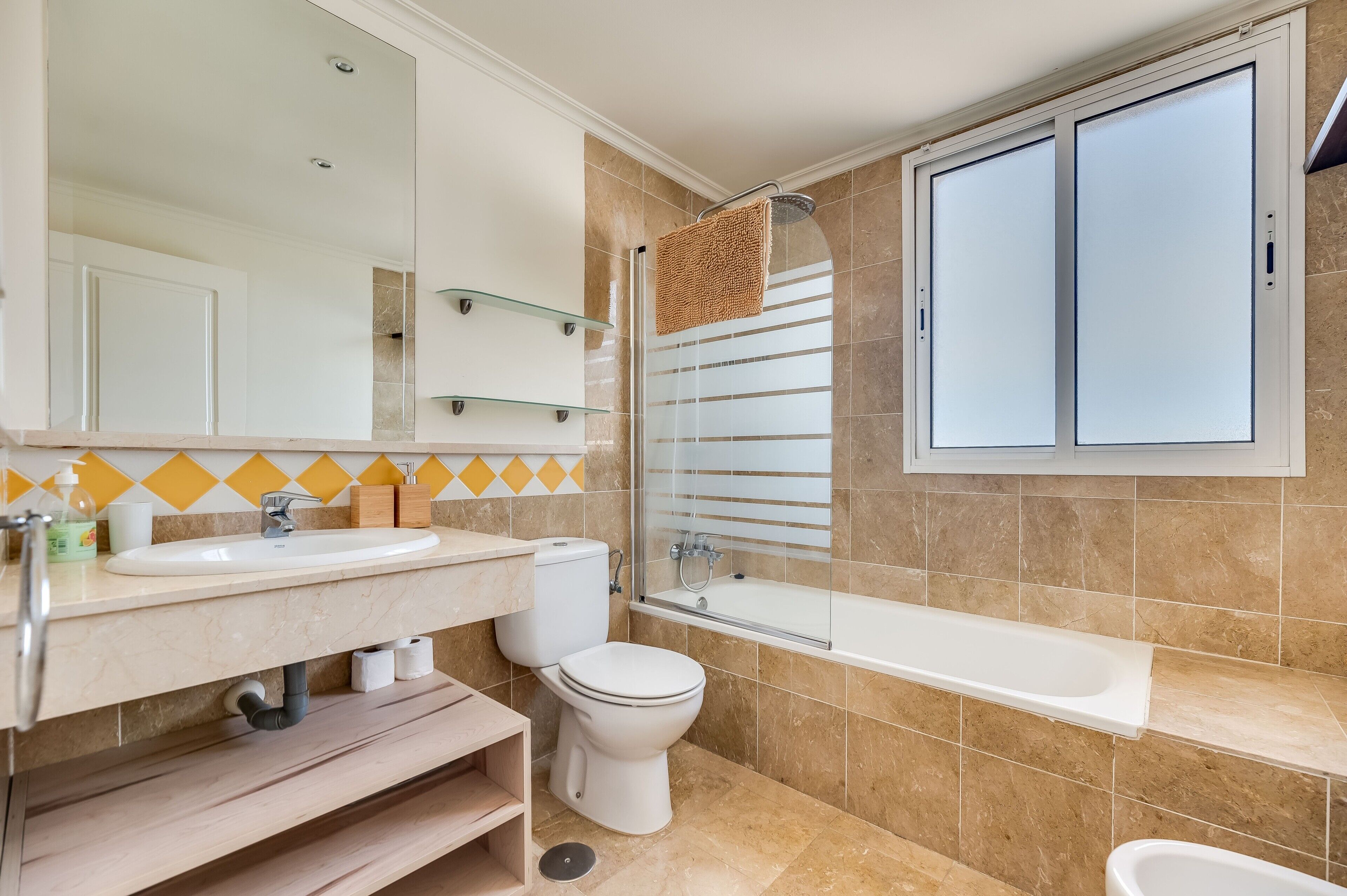 Un baño con lavamanos, inodoro y bañera.