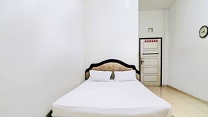 A single bed with white bedding in a small, narrow room with white walls and a tiled floor. - Hotel O Arizona Homestay (Jambi)