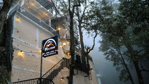 Edifici amb un cartell que diu "Mildaar Stay Safe" i una escala que condueix a un balcó.