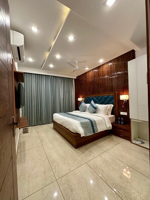 A modern bedroom with a large bed, wooden paneling, a ceiling fan, and recessed lighting. - Hotel Hilldaar Dalhousie (Dalhousie)