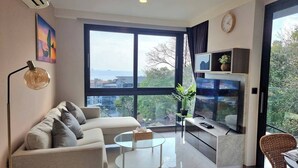 A modern living room with a sofa, coffee table, and a TV on a stand.