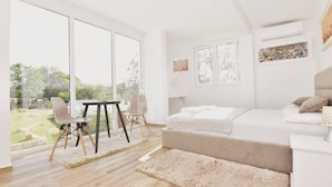 A modern bedroom with a large window, a bed, a bedside table, and a chair. - The Rock Star's Villa With Private Pool And Beach (Novo Selo)