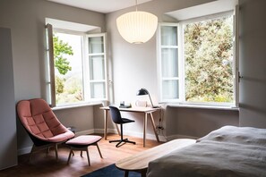 A bedroom with a bed, a desk, a chair, and two windows with a view of trees. - Villa Pacini - just 1,8 km outside Lucca Wall - Pool (Lucca)