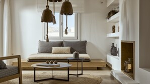 A modern living room with a sofa, a coffee table, and hanging lamps.