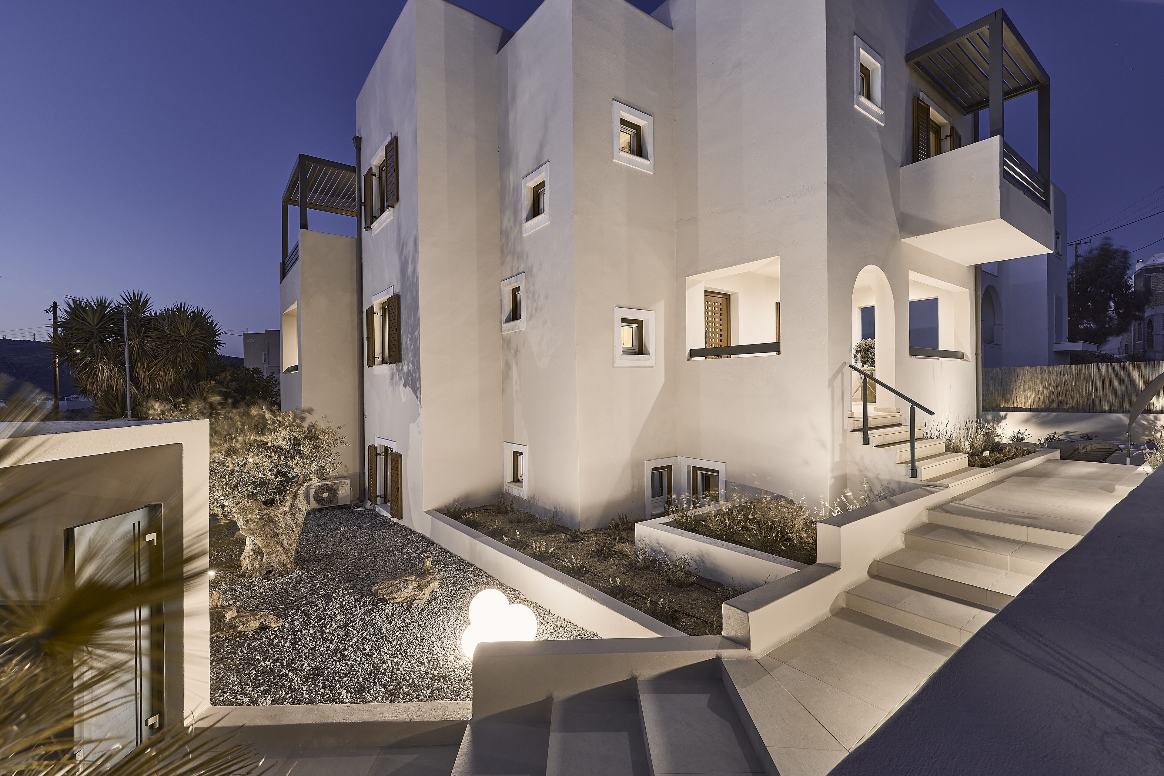 A modern multi-story building with a courtyard, outdoor staircase, and a pool area.