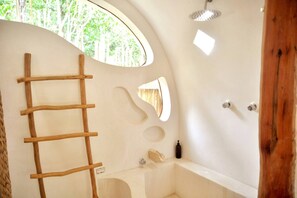 Bathroom features a unique design with a bathtub, shower area, and wooden ladder.