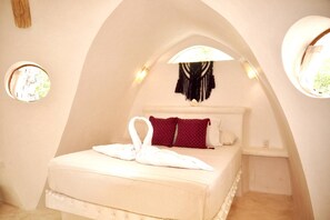 Experience a spacious retreat with a curved ceiling, a comfortable bed, and a cozy atmosphere.