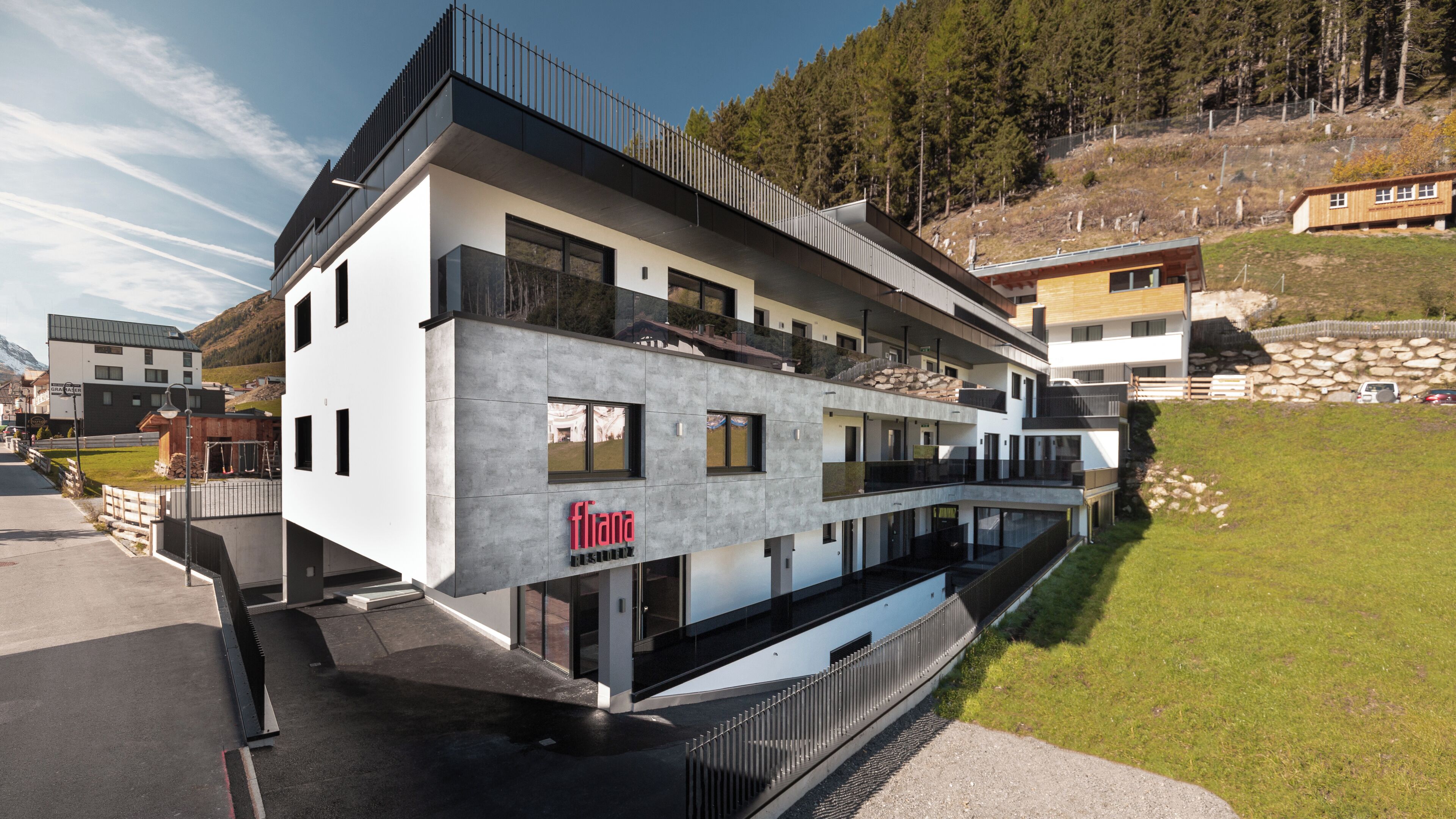 A modern multi-story building with a prominent 'fiona' sign, large windows, and a balcony on the upper floor.