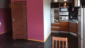 A modern kitchen with a built-in oven, microwave, and stainless steel range hood. - Apartament Promenada (Rzeszów)