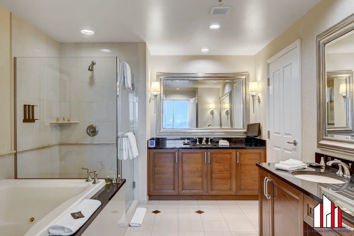 A modern bathroom with a large bathtub, a walk-in shower, and a vanity with a mirror.