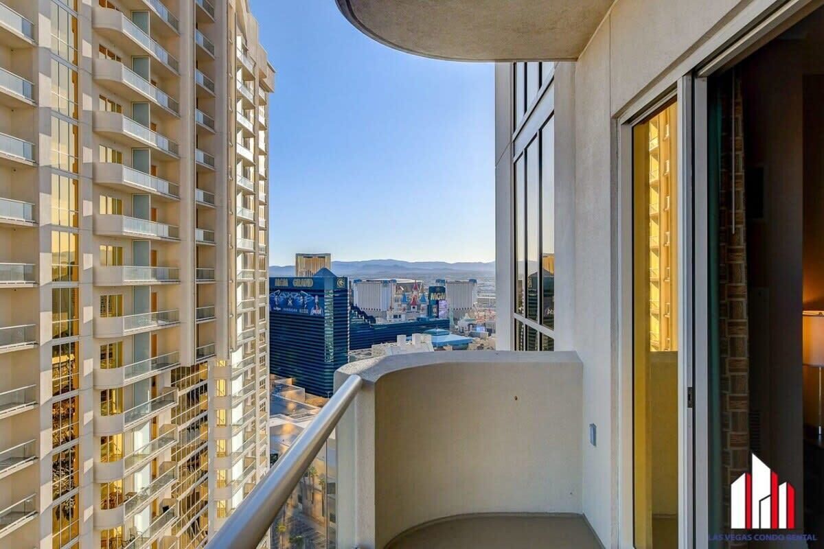 A high-rise building with multiple balconies and a view of the cityscape.