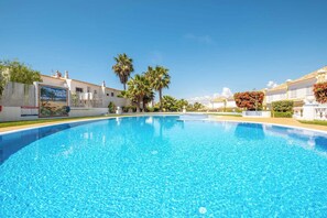 Relax by the serene pool surrounded by a mural of a beach scene and a trellis with vibrant flowers.