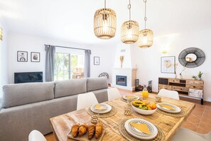 Enjoy meals in this stylish dining area with a fireplace and large window.