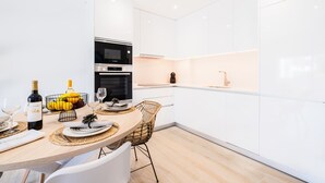 Une cuisine moderne avec des meubles blancs, un four encastré et un four à micro-ondes.