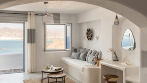 Un salón moderno con un sofá blanco, una mesa de centro redonda y vista al mar.
