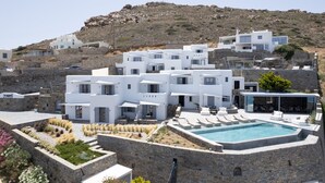Un moderno edificio blanco con piscina y zona de estar al aire libre.