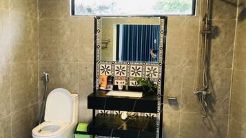 Un baño con inodoro, lavamanos y ducha.
