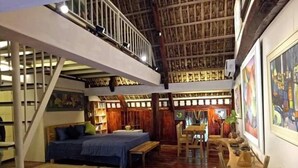 A spacious room with a high ceiling, a bed, a desk, and a dining area. - Muong Retreat (Thong Nhat)