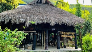 A thatched-roof structure with a sign reading "Fiji Land House" in a lush, green environment. - Muong Retreat (Thong Nhat)