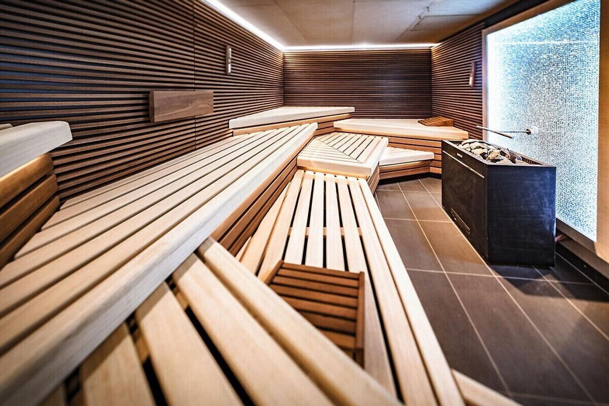Una sauna con bancos de madera y una pared de piedra.