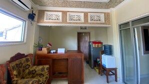 A living room with a sofa, a wooden coffee table, and a decorative ceiling. - Capital O 93124 Lombok Northis Homestay (Tanjung)
