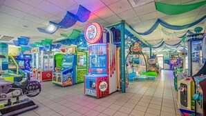 Een speelhal met diverse spelautomaten, waaronder een opvallend 'Wii Sports' spel.