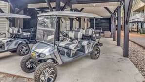 Un espace de stationnement couvert avec trois voiturettes de golf.