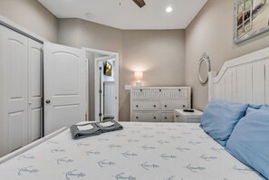Un dormitorio con cama, cómoda, tocador y puerta.