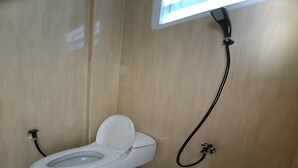 Kylpyhuone, jossa on wc, suihku ja ikkuna.