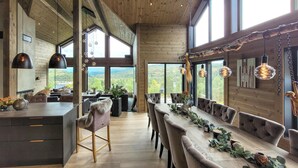 A spacious dining area with a long table, multiple chairs, and a view of the outdoors. - Awesome home in Norheimsund with sauna (Norheimsund)