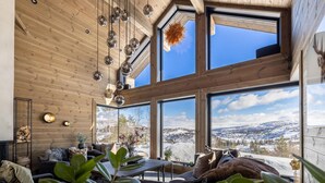 A spacious room with large windows offering a snowy mountain view, wooden ceiling, and modern decor. - Awesome home in Norheimsund with sauna (Norheimsund)