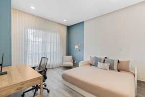 Ein modernes Schlafzimmer mit einem großen Bett, einem Schreibtisch und einem Sessel.