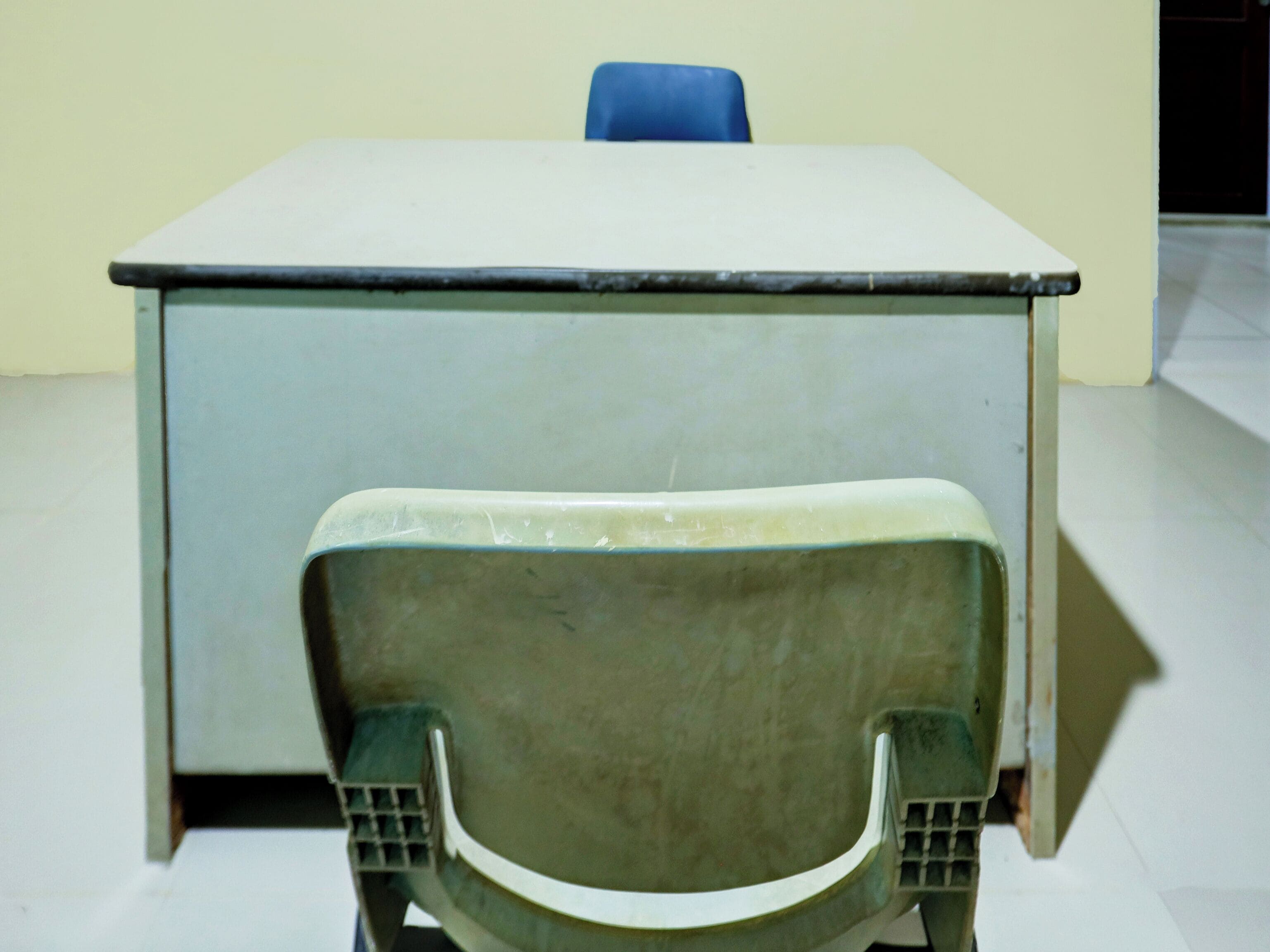 A room with a white table and a green chair.