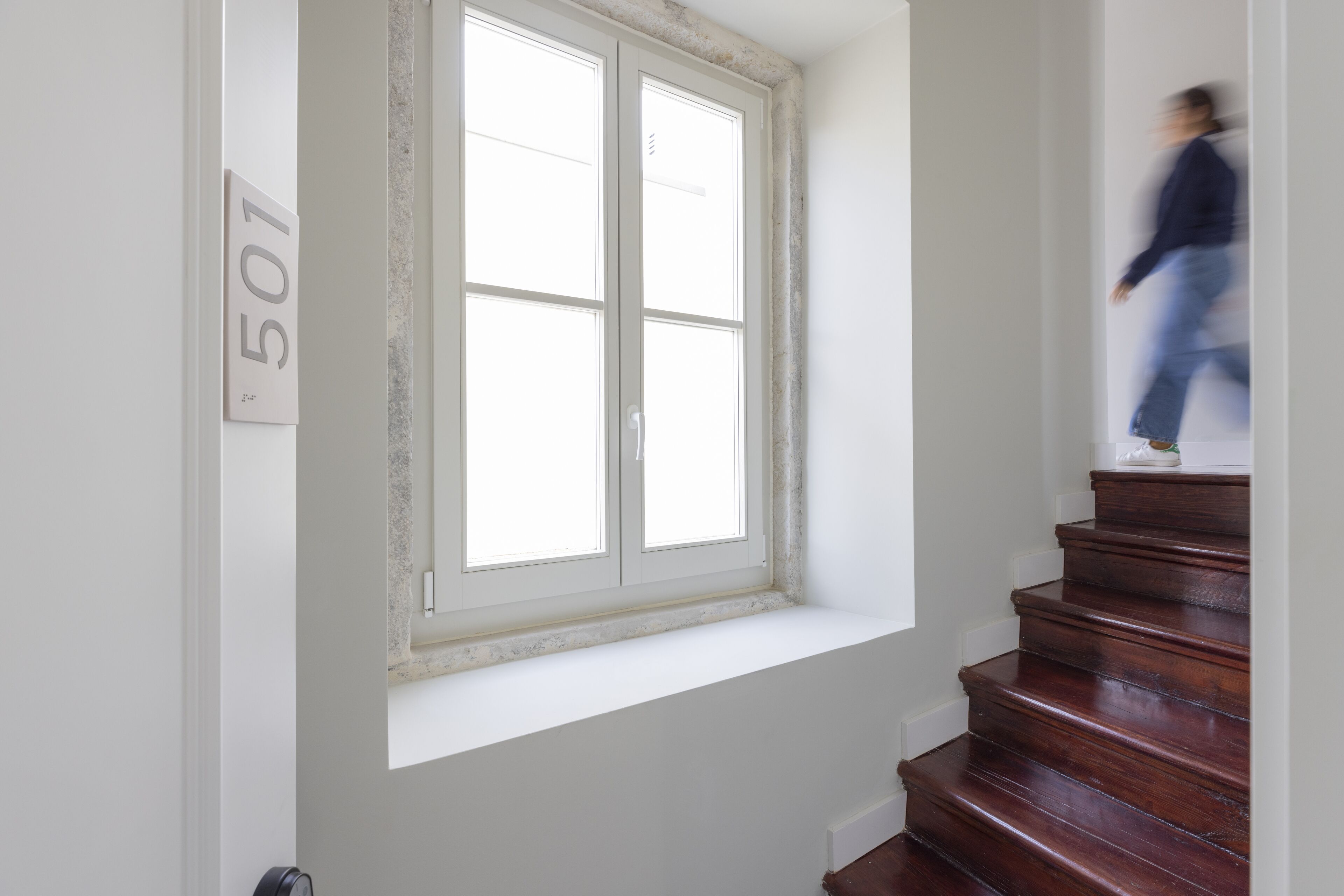 Una escalera con una ventana y una puerta marcada con el número 501.