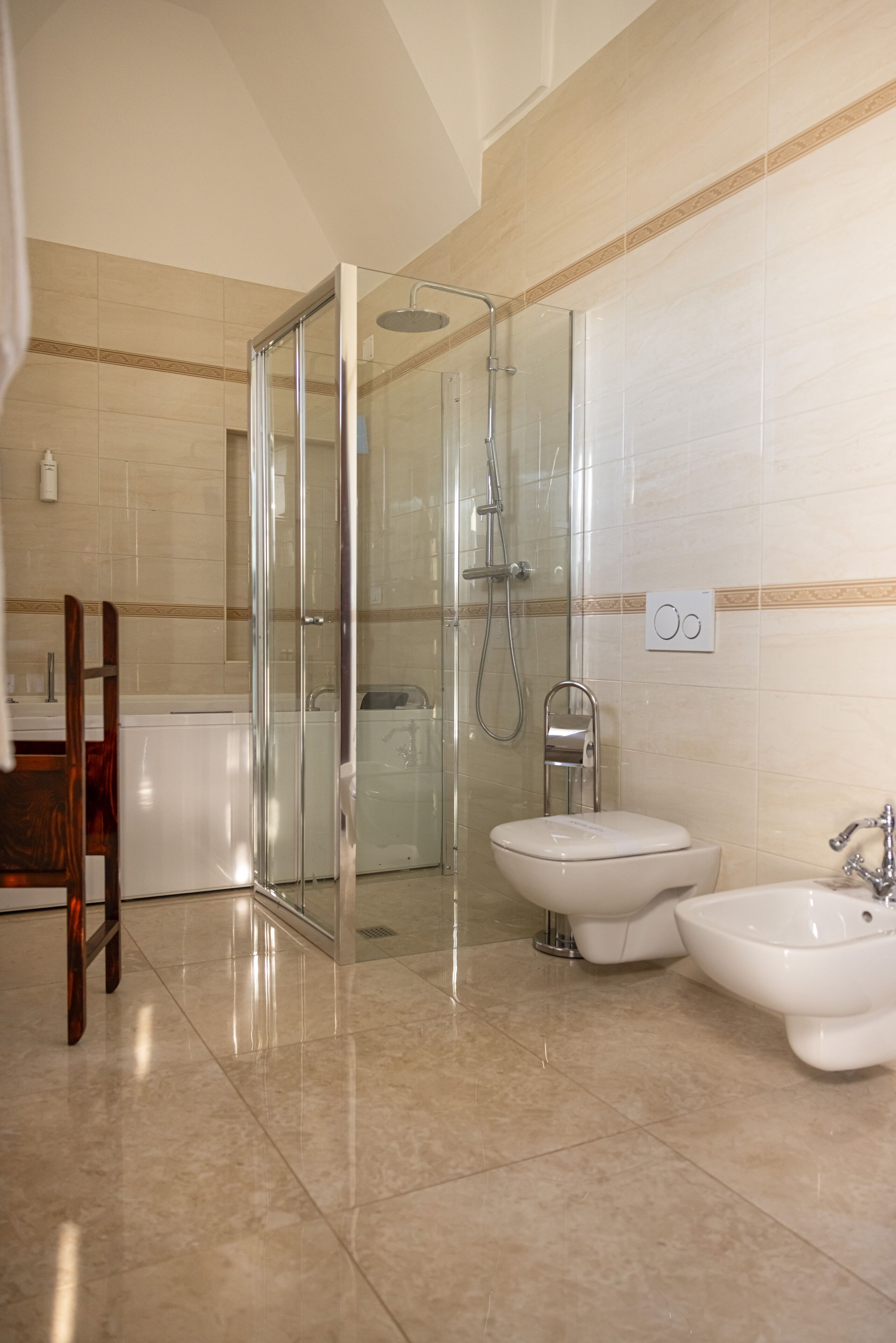 Un baño moderno con ducha acristalada, un bidé y un inodoro.