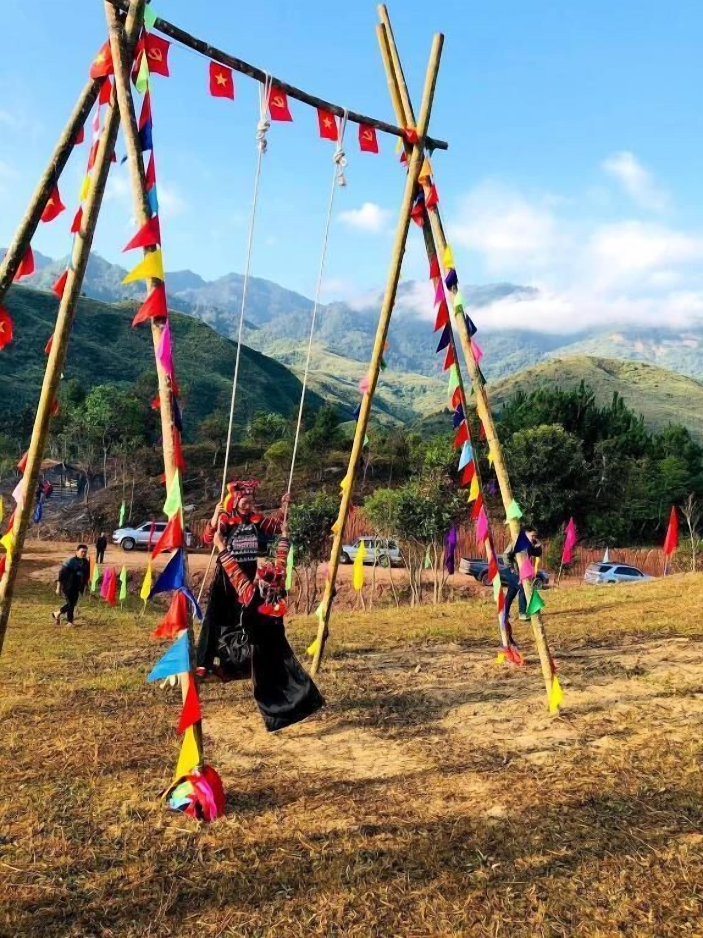 A traditional structure with colorful flags, set against a mountainous backdrop.