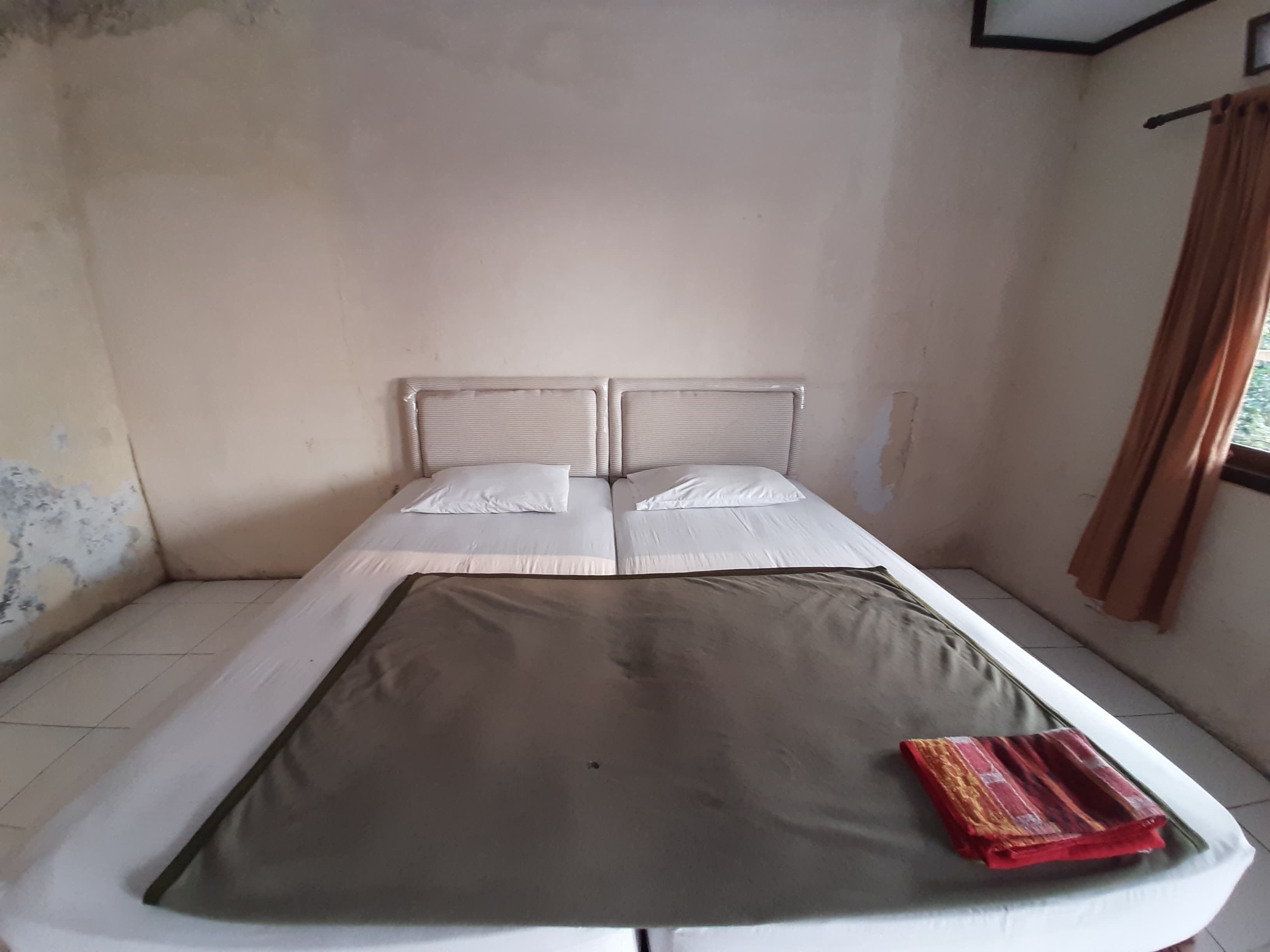 Una cama individual con cabecera, colchón y manta.