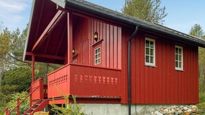 Un bâtiment en bois rouge, doté d’un porche abrité, d’un escalier et d’une enseigne sur laquelle on peut lire « VELKOMMEN ».