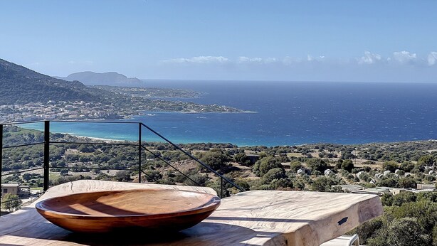 A coastal view with a wooden bowl on a table, overlooking a town and the sea. - Villa Casa di C (Corbara)