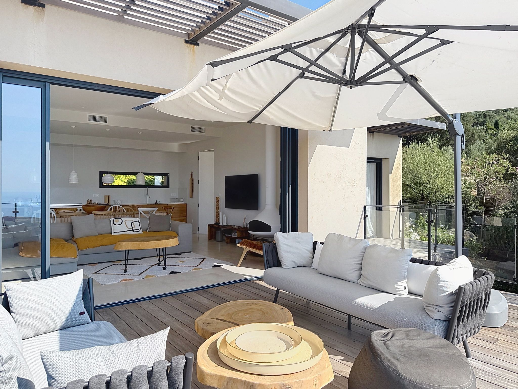 A modern outdoor living space with a sofa, chairs, and a dining table.