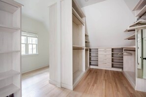 A walk-in closet with open shelving, drawers, and hanging space. - Carmelot (Atlanta)