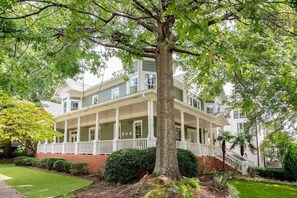 A two-story house with a covered porch and a brick foundation.