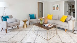 A modern living room with a sofa, two armchairs, a coffee table, and a floor lamp. - Creme Carmel (Atlanta)