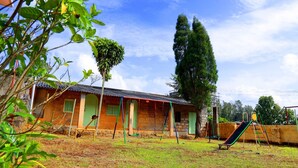 A residential area with a house, a swing set, and a slide.