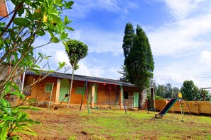 Un barrio residencial con una casa, un columpio y un tobogán.