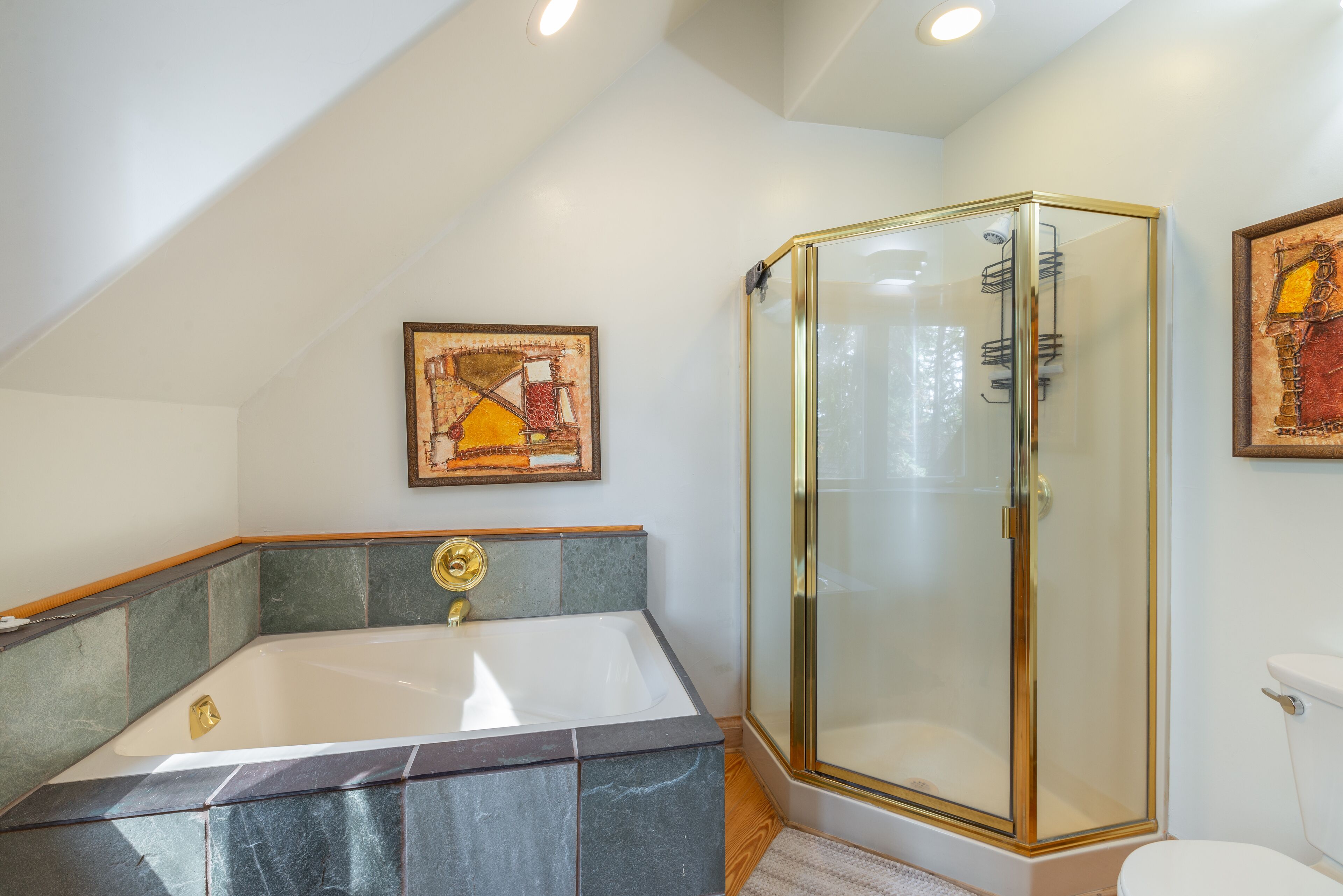 A bathroom with a freestanding bathtub, a glass-enclosed shower, and a toilet.