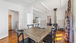 Un comedor con mesa de madera, sillas negras y una cesta tejida.