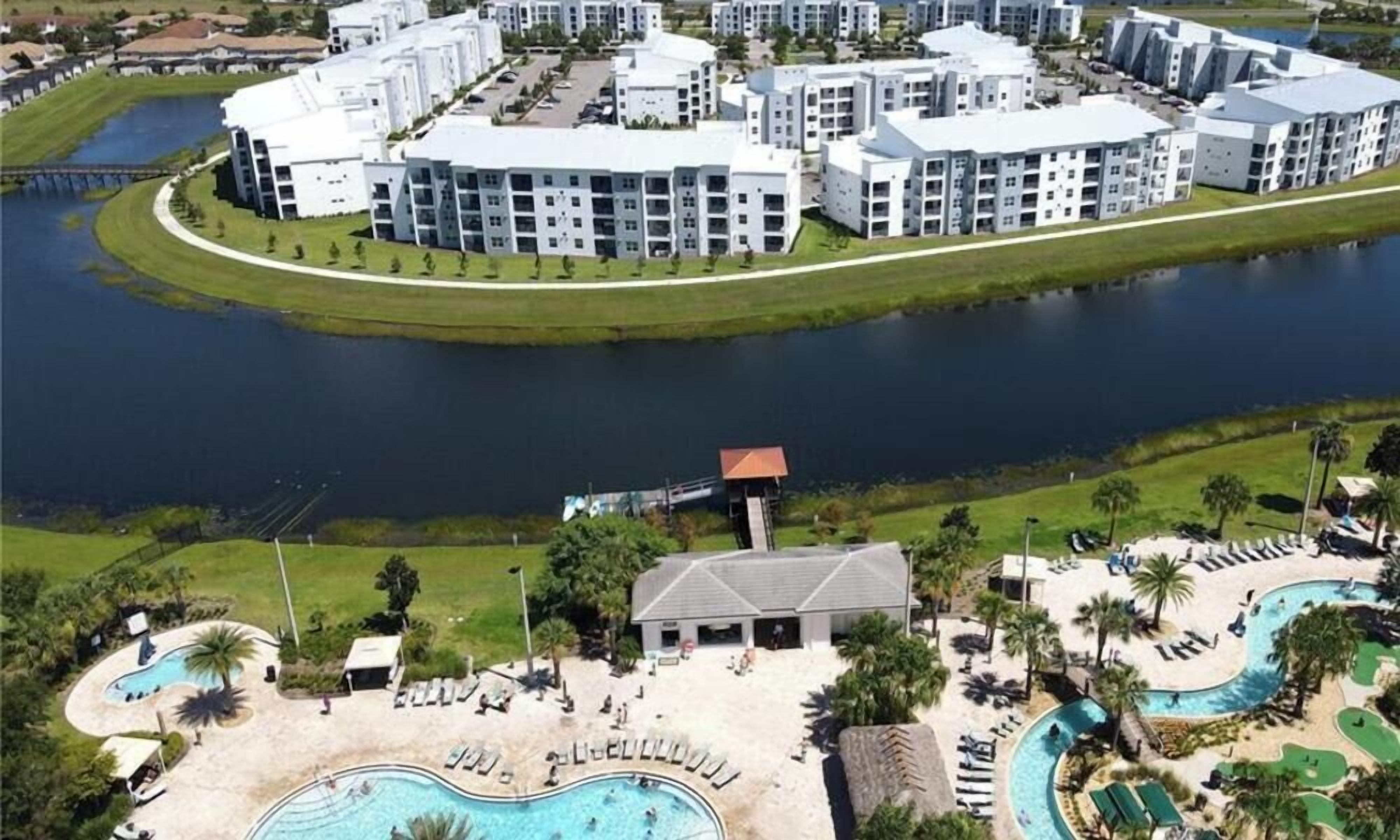 A resort with a central swimming pool, a separate pool area, and a large building complex with multiple floors.
