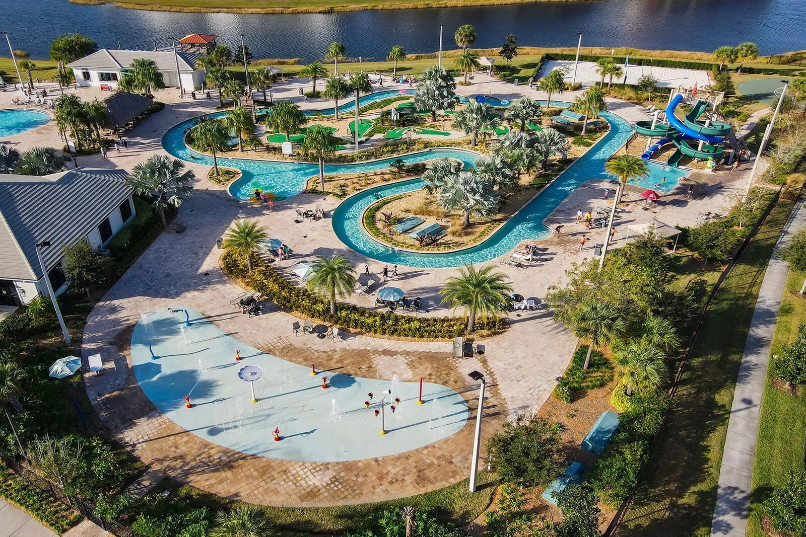 An aerial view of a resort with multiple swimming pools, a water park, and a beach area.